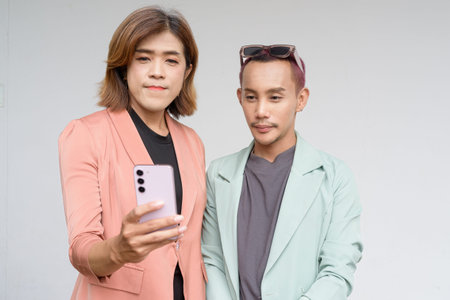 Transgender and non-binary Asian coworkers against plain background