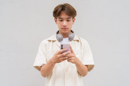 Non binary cute Asian young gay man portrait against plain background