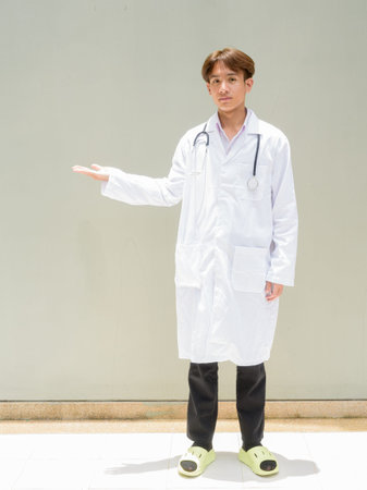 Young Asian healthcare worker wearing lab coat full body portraitの写真素材