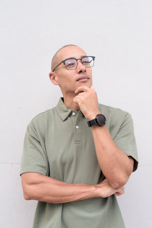 Latin adult man in his 40s with balding hair, posing confidently in studio against white background. Versatile image for business, education, healthcare or advertising use. Clear copy space.の写真素材