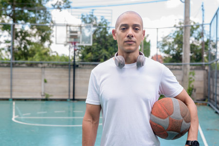 Hispanic man in sportswear posing on basketball court. Urban sports lifestyle, combining confidence,...
