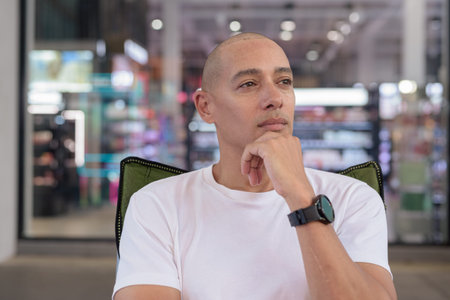 Hispanic man in his 40s posing confidently in an outdoor coffee shop restaurant. Warm, healthy,...