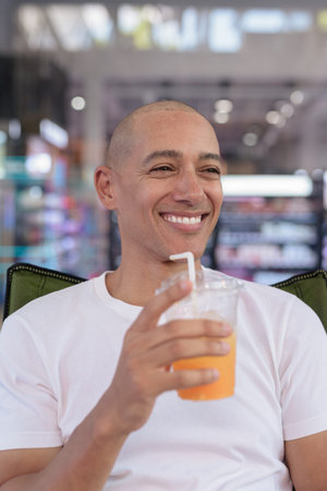 Hispanic man in his 40s posing confidently in an outdoor coffee shop restaurant. Warm, healthy,...