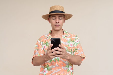 Happy Hispanic man wearing a Panama hat and tropical Hawaiian shirt, dressed in casual summer...