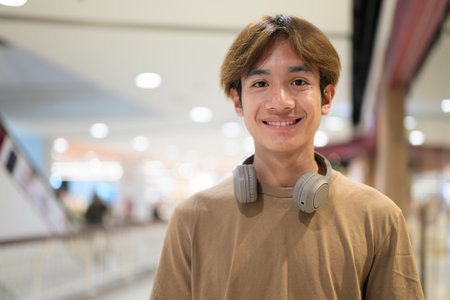 Handsome young Asian Thai man with headphones enjoying modern lifestyleの写真素材