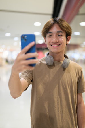 Handsome young Asian Thai man with headphones enjoying modern lifestyleの写真素材