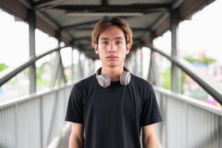 Portrait of a young Thai Asian man in casual style posing for modern lifestyle photography. Confident, relaxed, and authentic look suitable for various concepts and usesの写真素材