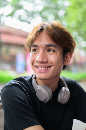 Portrait of a young Thai Asian man smiling in casual style posing for modern lifestyle photography. Confident, relaxed, and authentic look suitable for various concepts and usesの写真素材