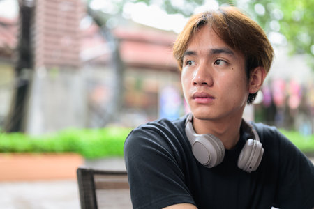 Portrait of a young Thai Asian man in casual style posing for modern lifestyle photography. Confident, relaxed, and authentic look suitable for various concepts and usesの写真素材