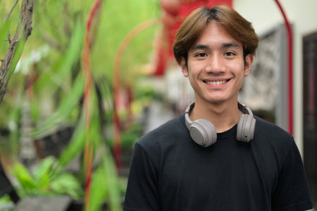 Young Thai Asian man in traditional Asian Zen garden during summer. Confident, relaxed, and authentic look suitable for various concepts and usesの写真素材