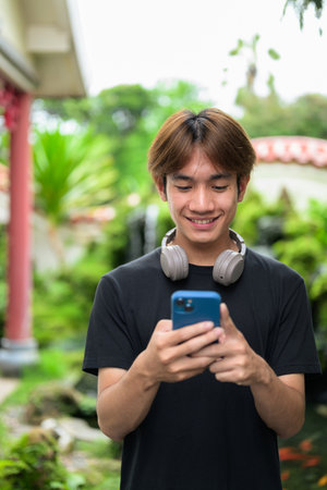 Young Thai Asian man in traditional Asian Zen garden during summer. Confident, relaxed, and authentic look suitable for various concepts and usesの写真素材