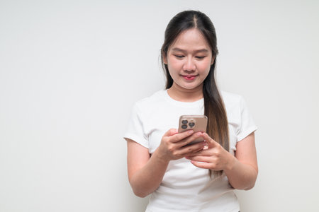 Studio portrait of young cute Asian woman against plain background wearing casual white t-shirtの写真素材