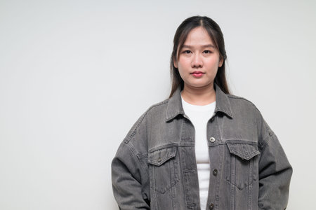 Studio portrait of young stylish Southeast Asian woman against white background