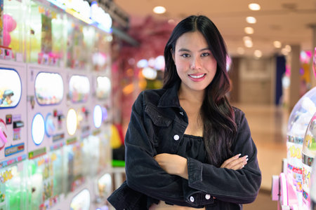Happy young Asian woman playing arcade video games indoors