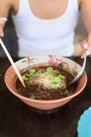 Famous Thailand street food boat noodles served at restaurant ready to be eaten by Asian woman