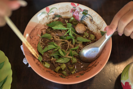Famous Thailand street food boat noodles served at restaurant ready to be eaten by Asian woman