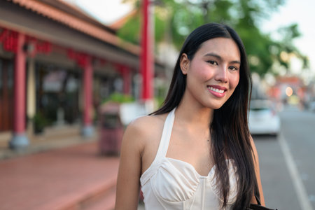 Young woman waiting for taxi at street during summer while smilingの写真素材