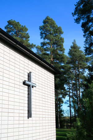 Cross on the wall of a Christian church in a pine forest.の写真素材