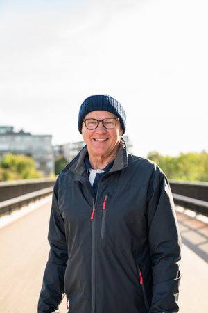 Portrait of a smiling senior man standing on a bridge in the cityの写真素材