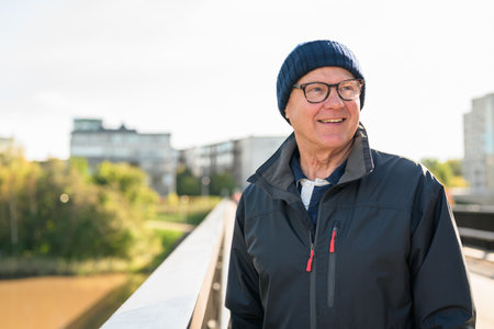 Portrait of a smiling senior man in sportswear on the bridgeの写真素材