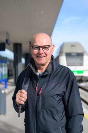 Portrait of smiling senior man with eyeglasses at train stationの写真素材