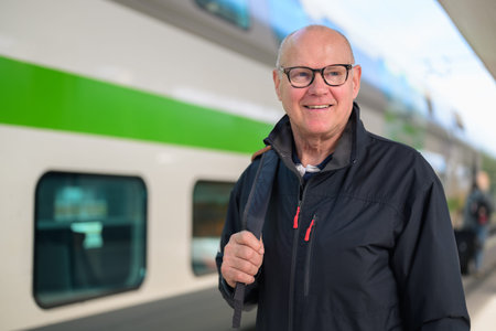 Portrait of smiling senior man with eyeglasses at train stationの写真素材
