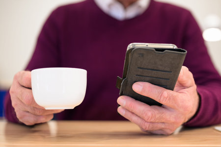 Closeup of a man hand using a smart phone during coffee break