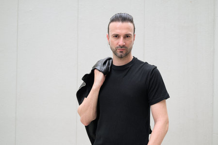 Confident bearded man wearing black leather jacket