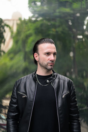 Confident bearded man wearing black leather jacket