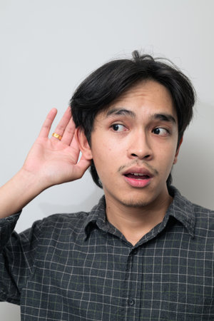 Portrait of handsome Young Asian Thai man in early 20s against white backgroundの写真素材