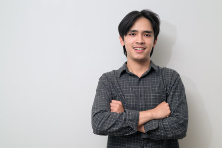 Portrait of handsome Young Asian Thai man in early 20s against white backgroundの写真素材