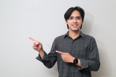 Portrait of handsome Young Asian Thai man in early 20s against white backgroundの写真素材