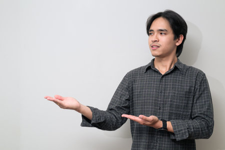 Portrait of handsome Young Asian Thai man in early 20s against white backgroundの写真素材