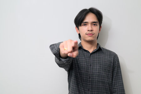 Portrait of handsome Young Asian Thai man in early 20s against white backgroundの写真素材