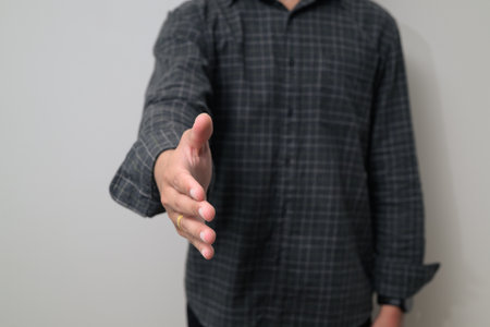 Portrait of young Asian man in early 20s against white backgroundの写真素材