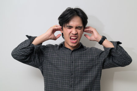 Portrait of handsome Young Asian Thai man in early 20s against white backgroundの写真素材