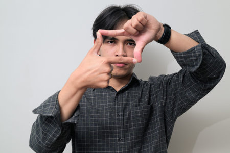Portrait of handsome Young Asian Thai man in early 20s against white background