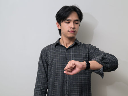 Portrait of handsome Young Asian Thai man in early 20s against white background