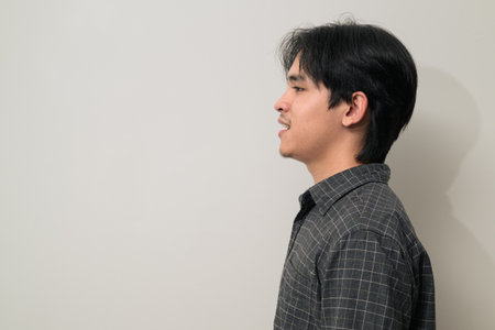 Portrait of handsome Young Asian Thai man in early 20s against white backgroundの写真素材