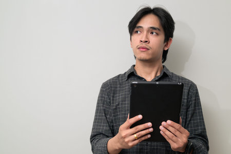 Portrait of handsome Young Asian Thai man in early 20s against white background