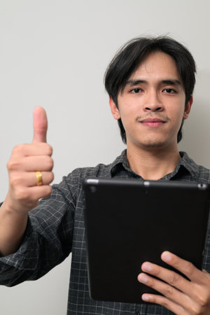 Portrait of handsome Young Asian Thai man in early 20s against white backgroundの写真素材