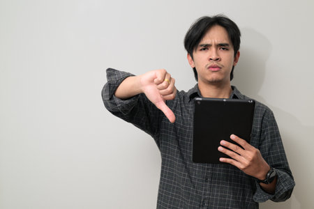 Portrait of handsome Young Asian Thai man in early 20s against white backgroundの写真素材