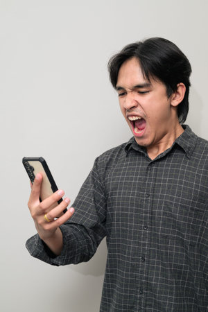 Portrait of handsome Young Asian Thai man in early 20s against white background