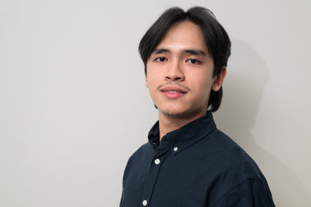 Portrait of handsome Young Asian Thai man in early 20s against white background