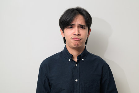 Portrait of handsome Young Asian Thai man in early 20s against white backgroundの写真素材