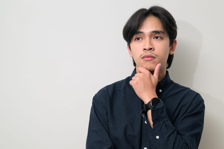 Portrait of handsome Young Asian Thai man in early 20s against white background