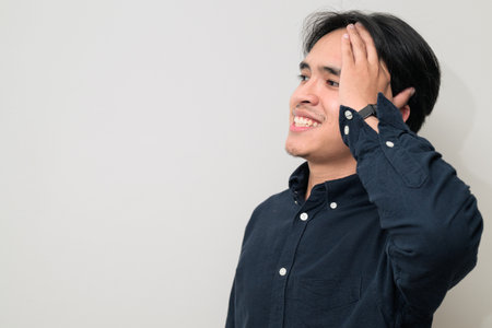 Portrait of handsome Young Asian Thai man in early 20s against white backgroundの写真素材