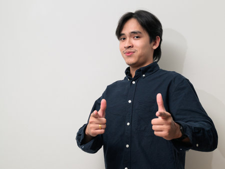 Portrait of handsome Young Asian Thai man in early 20s against white backgroundの写真素材