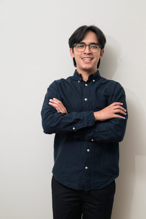 Portrait of handsome Young Asian Thai man in early 20s against white background