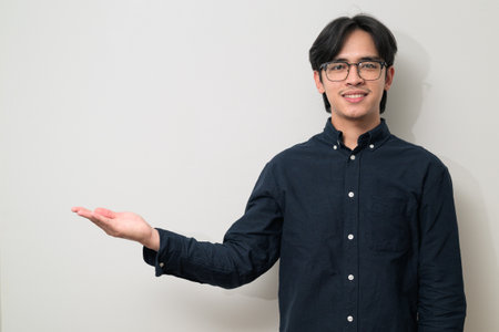 Portrait of handsome Young Asian Thai man in early 20s against white backgroundの写真素材
